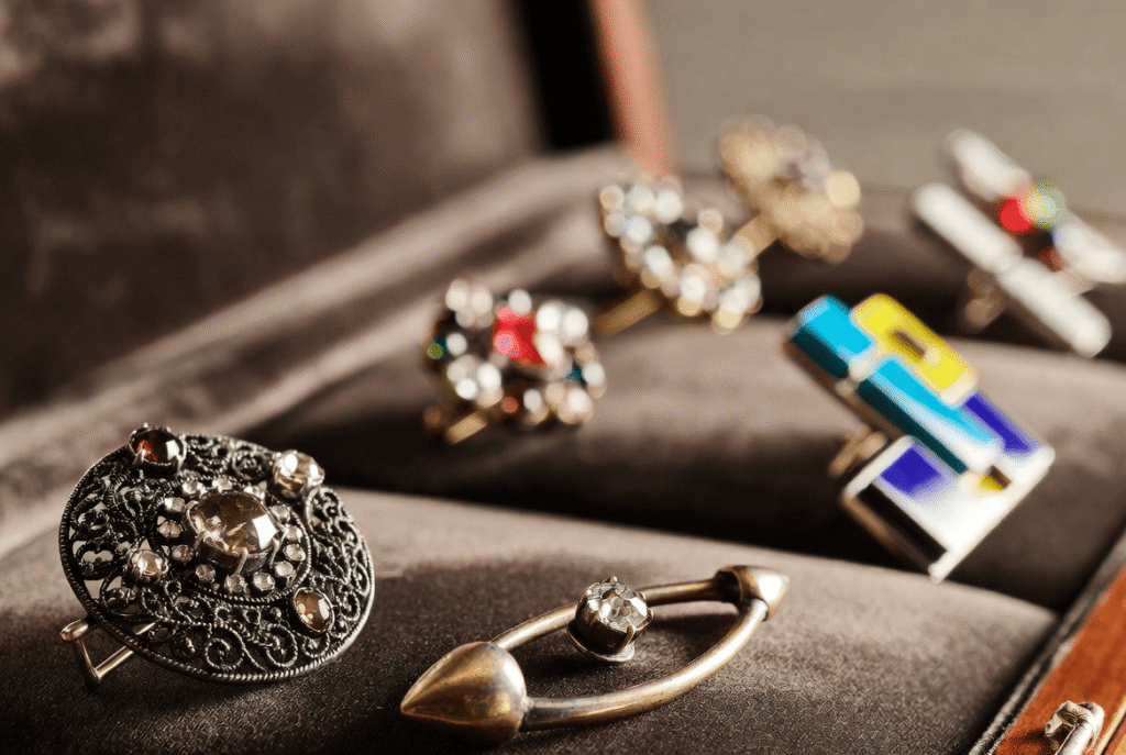 A stunning collection of brooch aesthetic jewelry featuring vintage gold cameos, modern crystal statement pieces, and pearl clusters artfully arranged on soft velvet. The display captures the timeless elegance and diversity of brooch design for ladies, from heirloom treasures to luxury designer brooches.